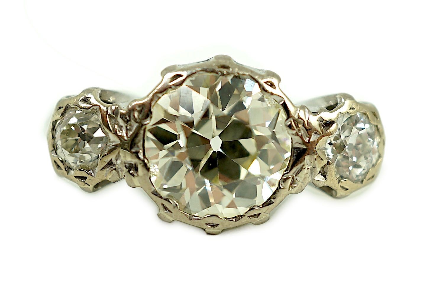 A white gold and collet set three stone diamond ring, the central stone weight approximately 2.08ct